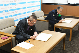 協定書にサインする浅野市長と山田各務原警察署長の写真