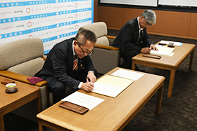協定書に署名する浅野市長と岩佐代表理事組合長の写真
