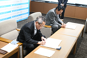 協定を締結する浅野市長と荒木賢治会長