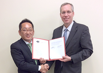 覚書を手にする浅野健司市長とジョン・バナー副学長の写真
