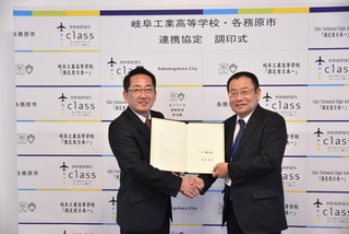 協定書を手にする浅野健司市長と江口健治郎校長の写真