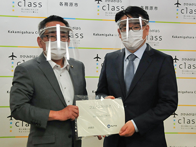 フェイスシールドを手渡す田中取締役社長