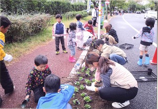 ボランティアが植樹ますの花かざりをしている写真