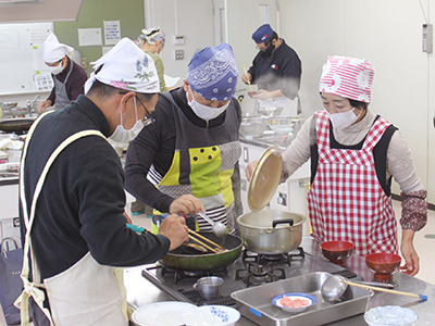 調理をする参加者らの写真