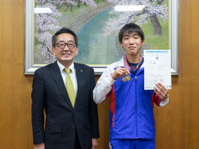 メダルを持つ倉富さんの写真