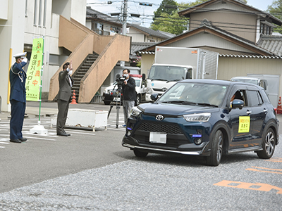 出発する車両を見送る市長らの写真