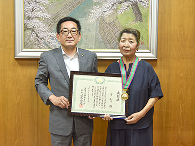 表彰状を手に記念撮影する市長と宮さん