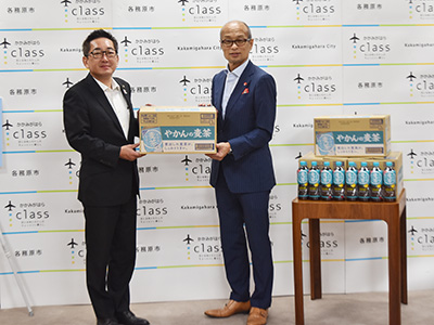 コカ・コーラボトラーズジャパン製品を手渡している写真