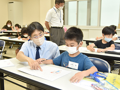 絵本作り講座の講師と受講した小学生の写真