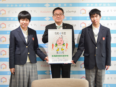 カレンダーを手に記念撮影する市長と永田さん・染谷さん
