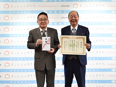 目録と感謝状を手にする市長と石田・代表取締役の写真