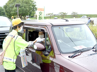 交通安全啓発物品を車の運転者に配布している写真