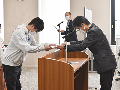 教育長が成績優秀者に認定証を授与している写真