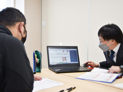 診断結果が表示されたパソコン画面を見る参加者の写真