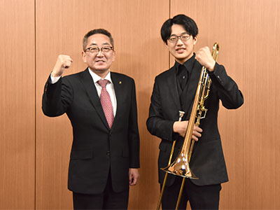 トロンボーンを持つ岩間さんと浅野市長の写真