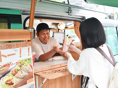 キッチンカーの店員から商品を受け取っている写真