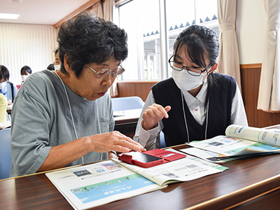 スマホ操作をしている高齢者と学生