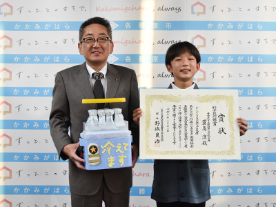 蓑島さんが賞状を、浅野市長が作品を持っている写真