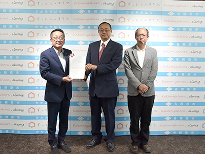 答申書をもって記念撮影を受ける浅野市長、北角会長、富樫副会長