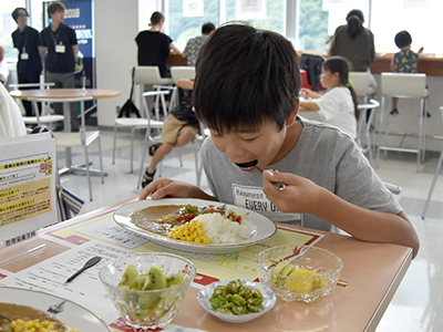 夏野菜カレーをほおばる子ども