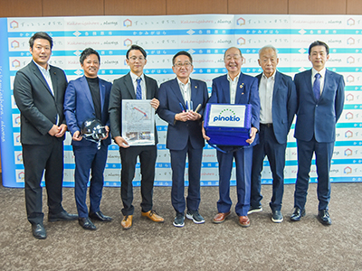 訓練で配送する予定の医薬品を持つ、浅野市長、ピノキオ商事株式会社、クロステックフィールドジャパン株式会社の写真