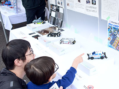 出展されたミニ四駆を見る来場者の写真
