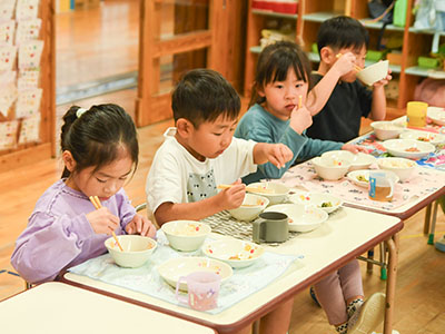 にんじんを取り入れた給食を食べる園児の写真