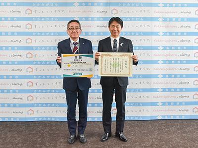 目録と感謝状を手に持ち記念撮影を受ける浅野市長と明治安田生命保険相互会社の加藤支社長の写真