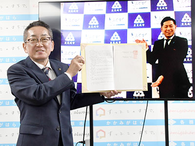 協定書を持つ浅野市長と沖縄県豊見城市長の写真