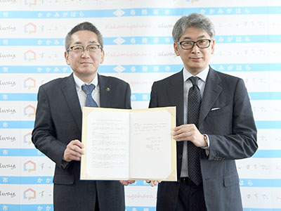 協定書を持つ浅野市長と長田役員の写真