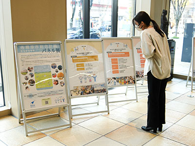 市役所に掲示された各務原市総合計画のパネルを見る来庁者の写真