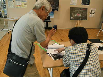 福手一義調査員の説明を熱心に聞く池田光巳さん