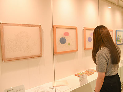 アートウィンドウで開催中の企画展「南谷具代展ー絵絹に描くー」作品を見る来庁者