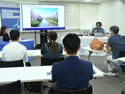 移住セミナーで写真を見ながら市の魅力を話す小林さんの写真