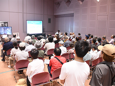 展示室内のセミナーブースでミニ講座を聞く来場者ら