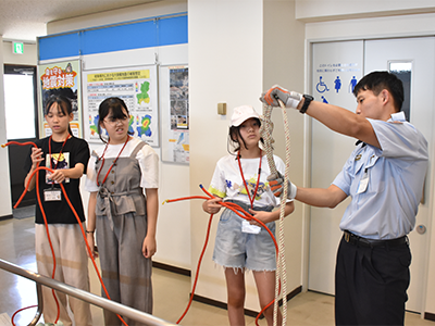 職員の説明を受けながらロープ結びを学ぶ子どもたち