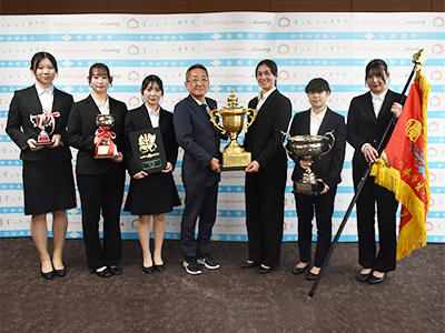 優勝カップを持って浅野市長と並ぶ選手たちの写真