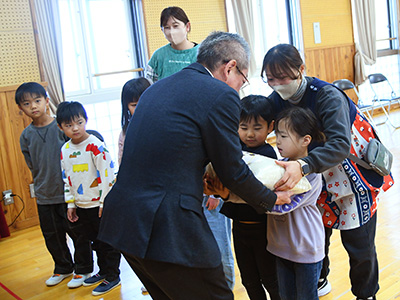 浅野市長が園児に御膳籾を手渡す様子