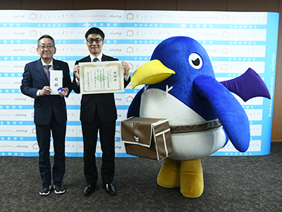 浅野市長と並ぶ猿橋社長とプリニーの様子