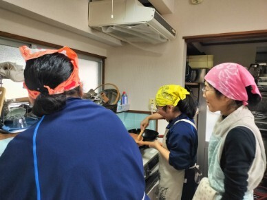 調理を担う高校生たちにやさしく教えるおひさまのおうちスタッフ