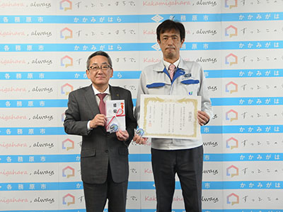 目録を持つ浅野市長と、感謝状を持つ桜井宏・常務役員