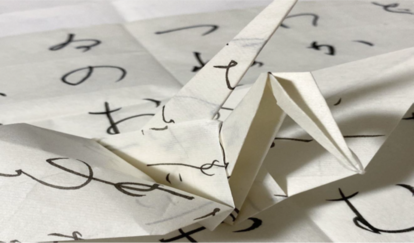 鶴の折り紙。細い筆で文字が書かれている。