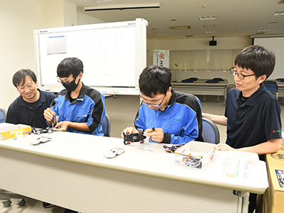 HIGUCHIの社員に教わりながらミニ四駆を組み立てる生徒