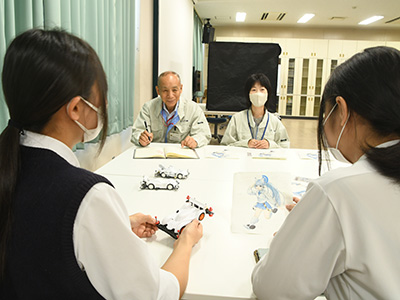ミツワの社員にデザインの説明をする生徒