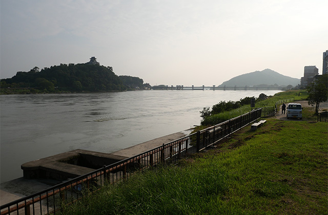 増水した木曽川と濁流に洗われた河畔遊歩道の写真