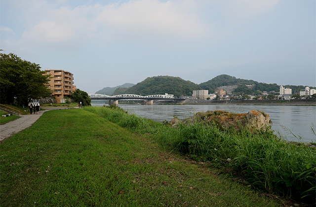 増水した木曽川と濁流に洗われた河畔遊歩道の写真