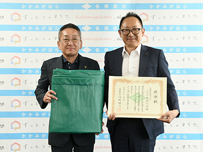 寄贈されたシートを持った市長らの写真